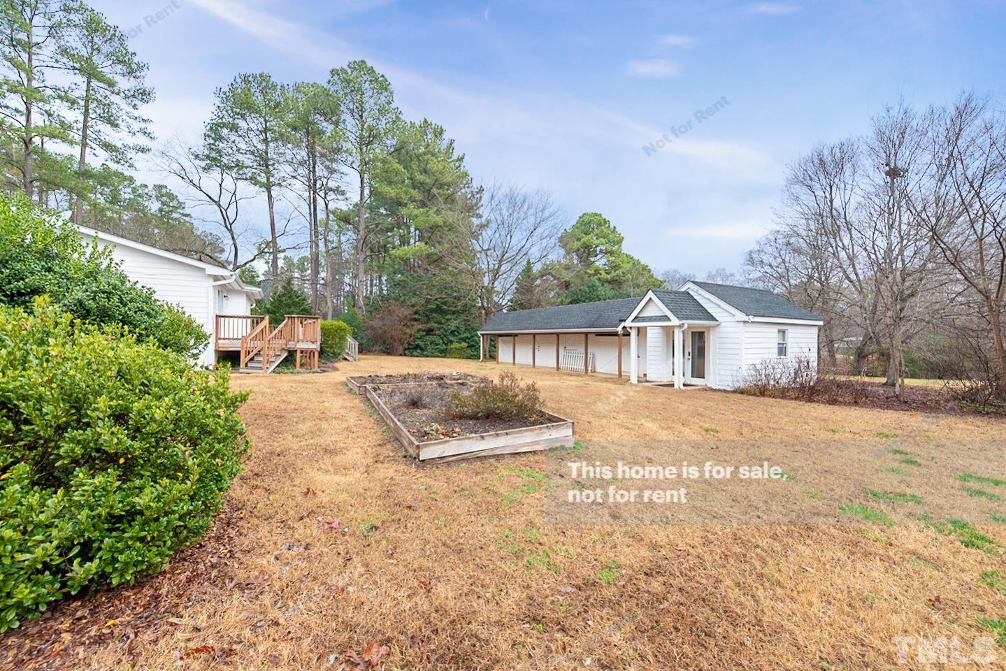 12008 Shooting Club Road Raleigh, NC 27613 - Photo 17 of 23 a view of house with yard and trees in the background