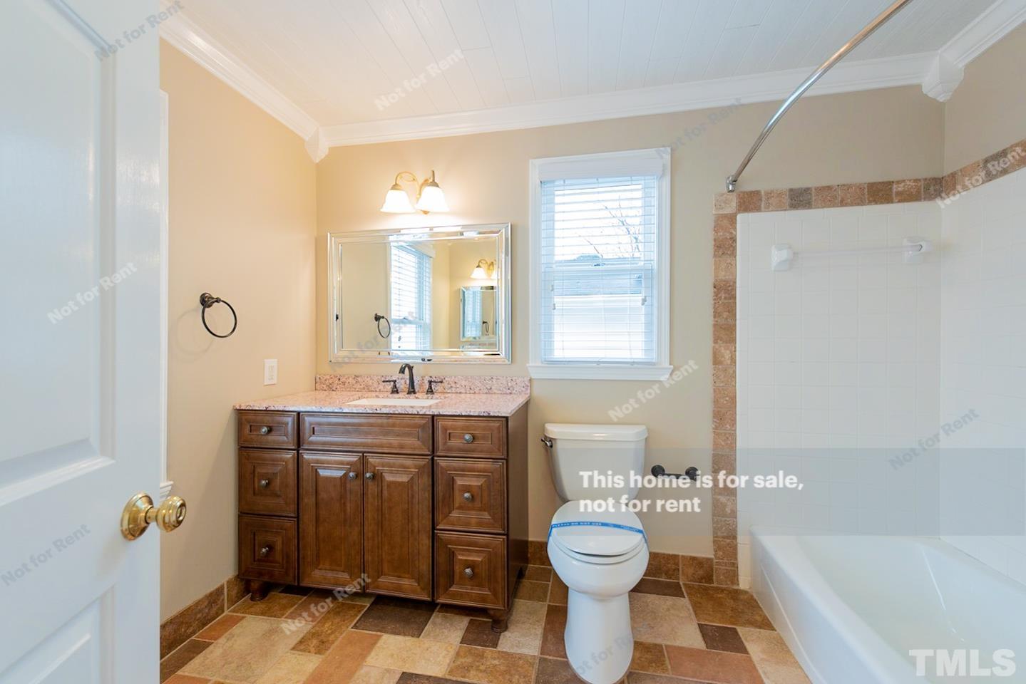 12008 Shooting Club Road Raleigh, NC 27613 - Photo 4 of 23 a bathroom with a sink a toilet and shower