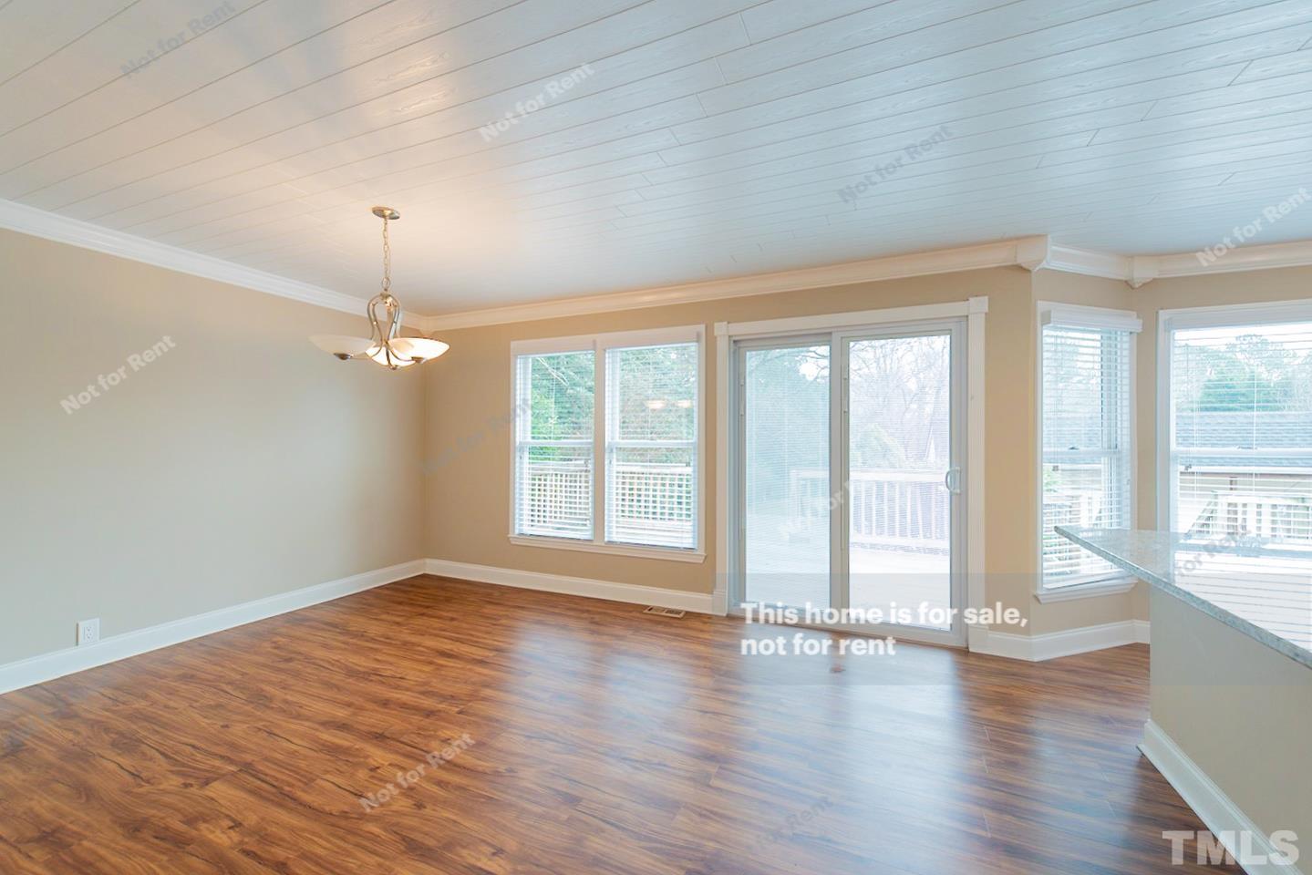 12008 Shooting Club Road Raleigh, NC 27613 - Photo 8 of 23 a view of an empty room with wooden floor and a window