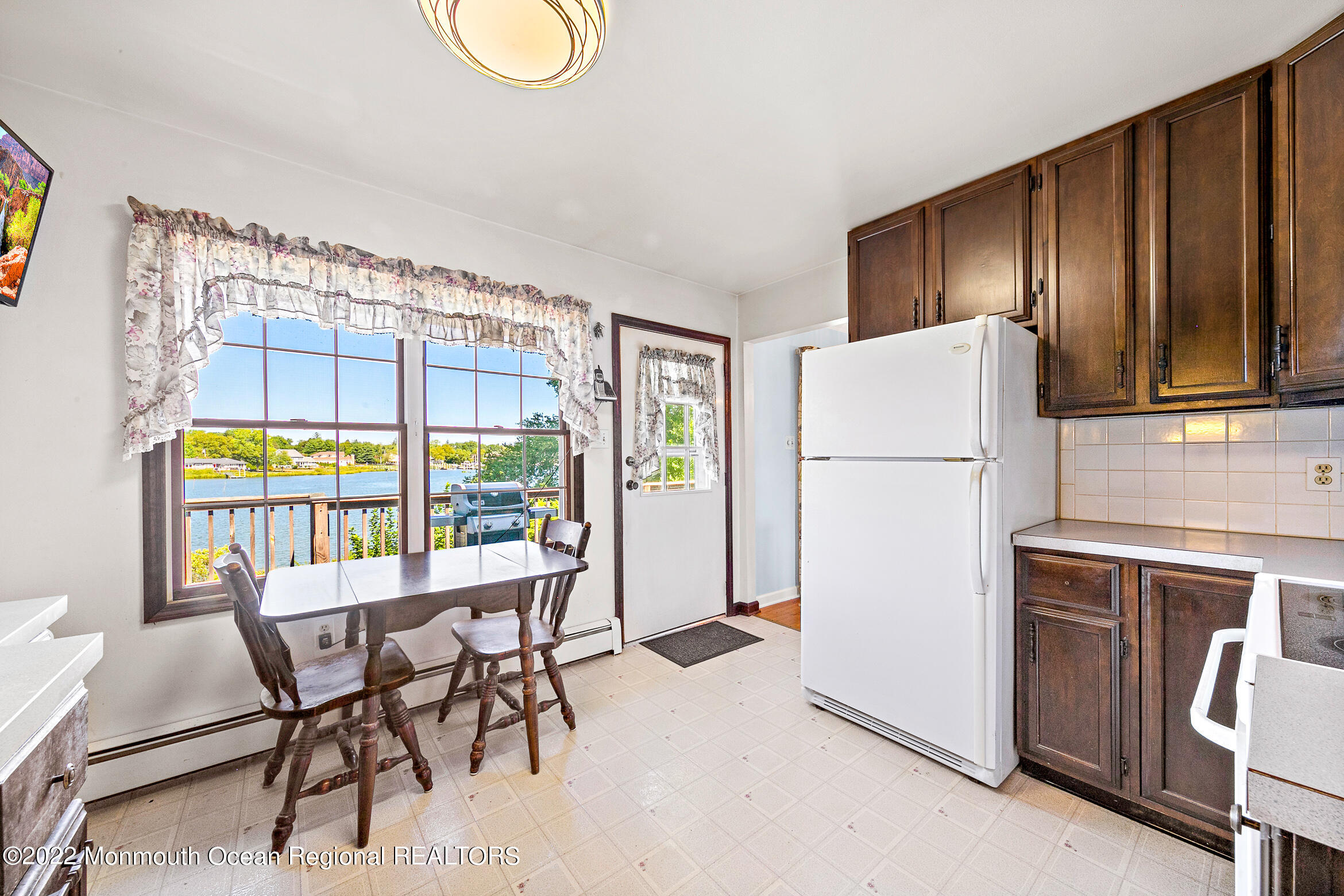 69 Horseneck Point Road Oceanport, NJ 07757 - Photo 6 of 22 a dining room with furniture a refrigerator and kitchen view