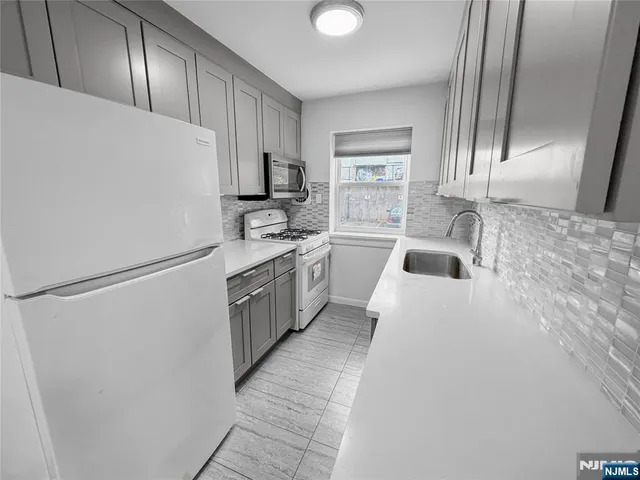 a kitchen with stainless steel appliances a refrigerator sink and cabinets