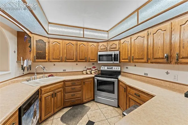 a kitchen with stainless steel appliances granite countertop a sink stove and microwave