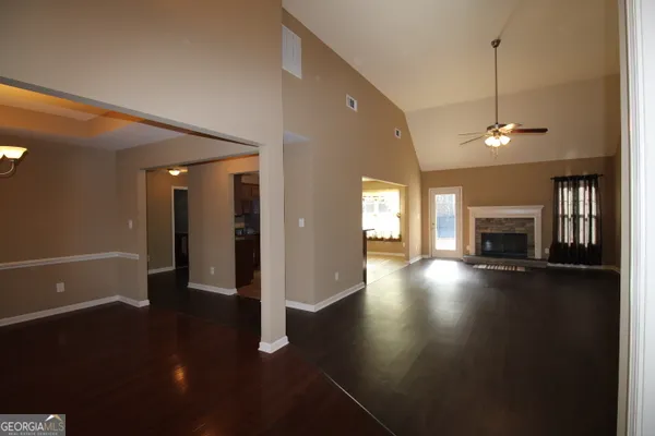 a view of a livingroom with wooden floor and a fireplace