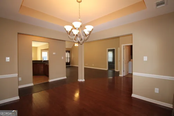 a view of a big room with wooden floor and chandelier