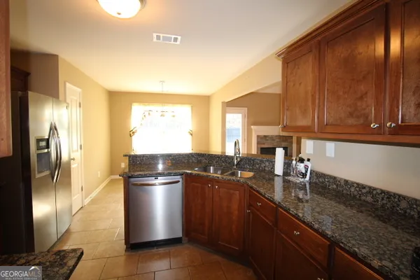 a kitchen with stainless steel appliances granite countertop a sink a stove and a refrigerator