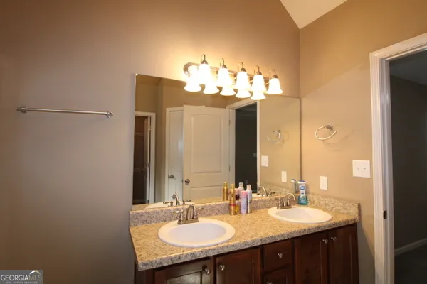 a bathroom with a double vanity sink and a mirror