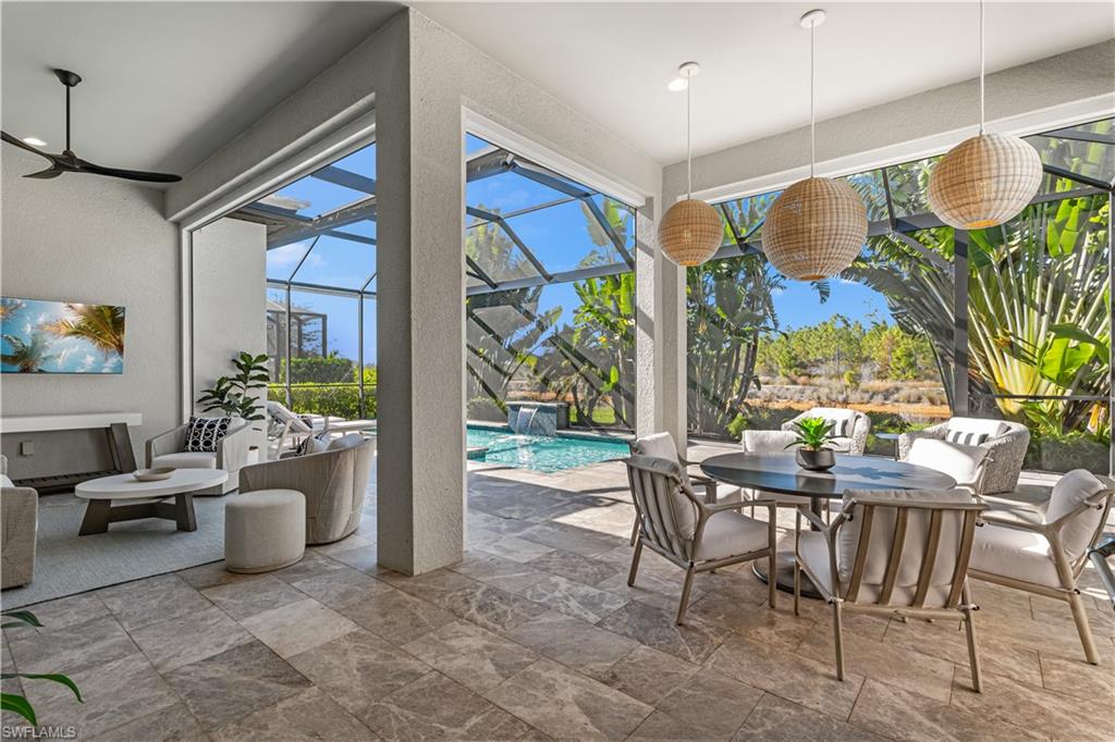 9517 Montelanico Loop Naples, FL 34119 - Photo 14 of 50 a view of a dining room with furniture one side kitchen view and wooden floor