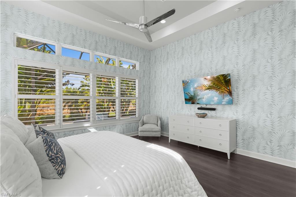 9517 Montelanico Loop Naples, FL 34119 - Photo 17 of 50 a bedroom with a bed and a flat tv screen on dresser