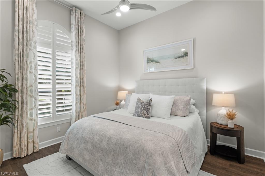 9517 Montelanico Loop Naples, FL 34119 - Photo 20 of 50 a bedroom with a bed and a chair