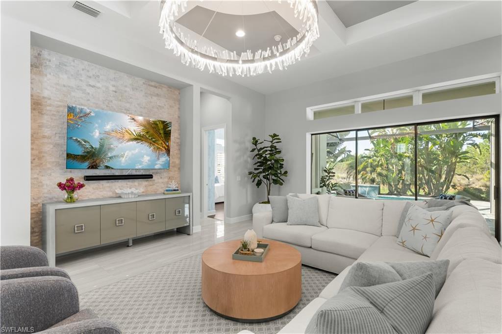 9517 Montelanico Loop Naples, FL 34119 - Photo 2 of 50 a living room with furniture and a flat screen tv