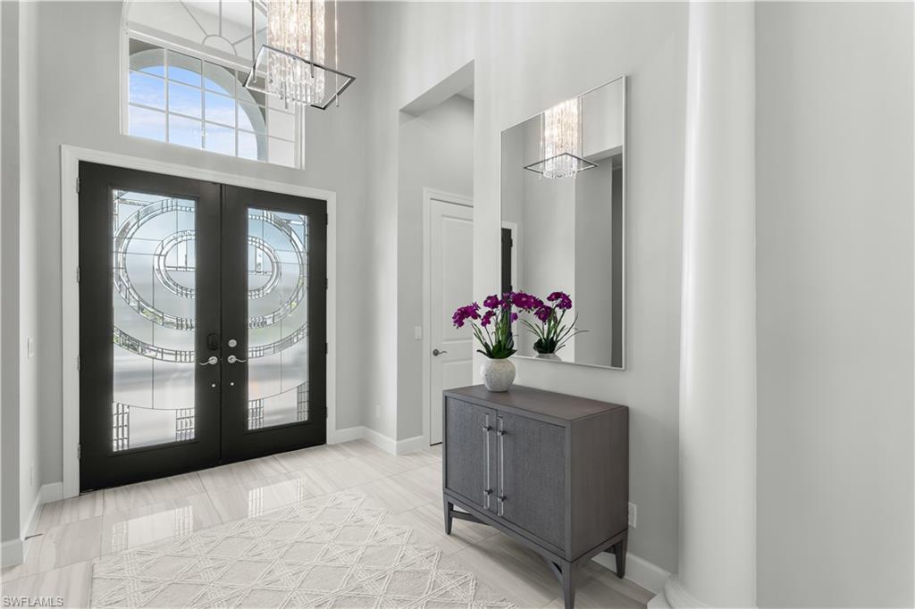 9517 Montelanico Loop Naples, FL 34119 - Photo 25 of 50 a view of a hallway with furniture and a chandelier