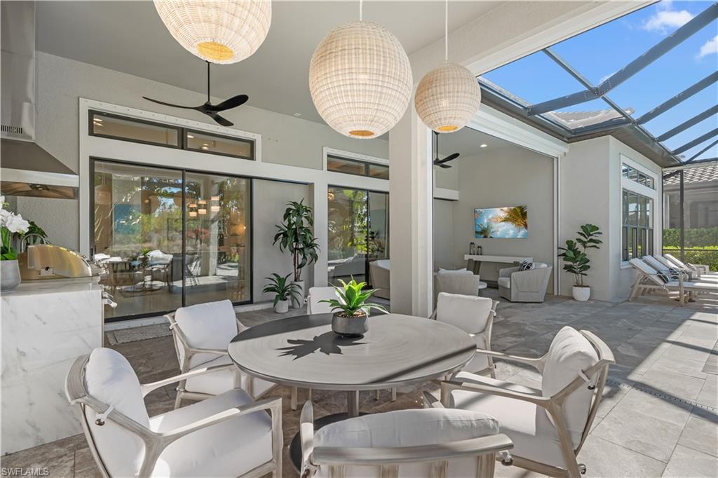 9517 Montelanico Loop Naples, FL 34119 - Photo 28 of 50 a view of a dining room with furniture large windows and wooden floor