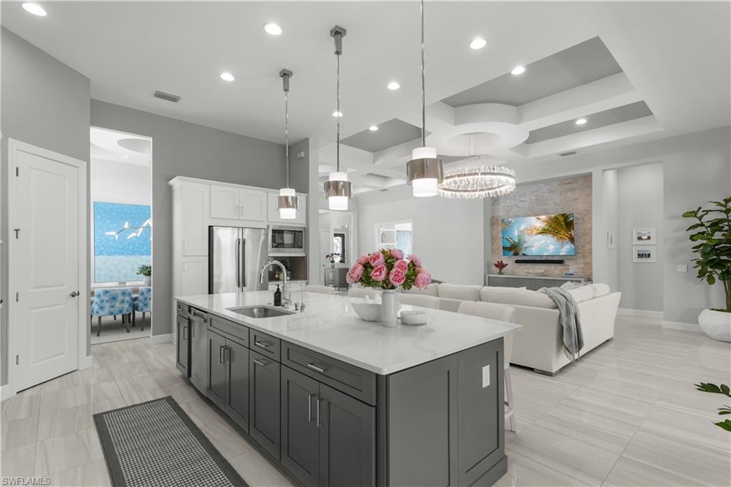 9517 Montelanico Loop Naples, FL 34119 - Photo 9 of 50 a view of kitchen island a sink and a refrigerator