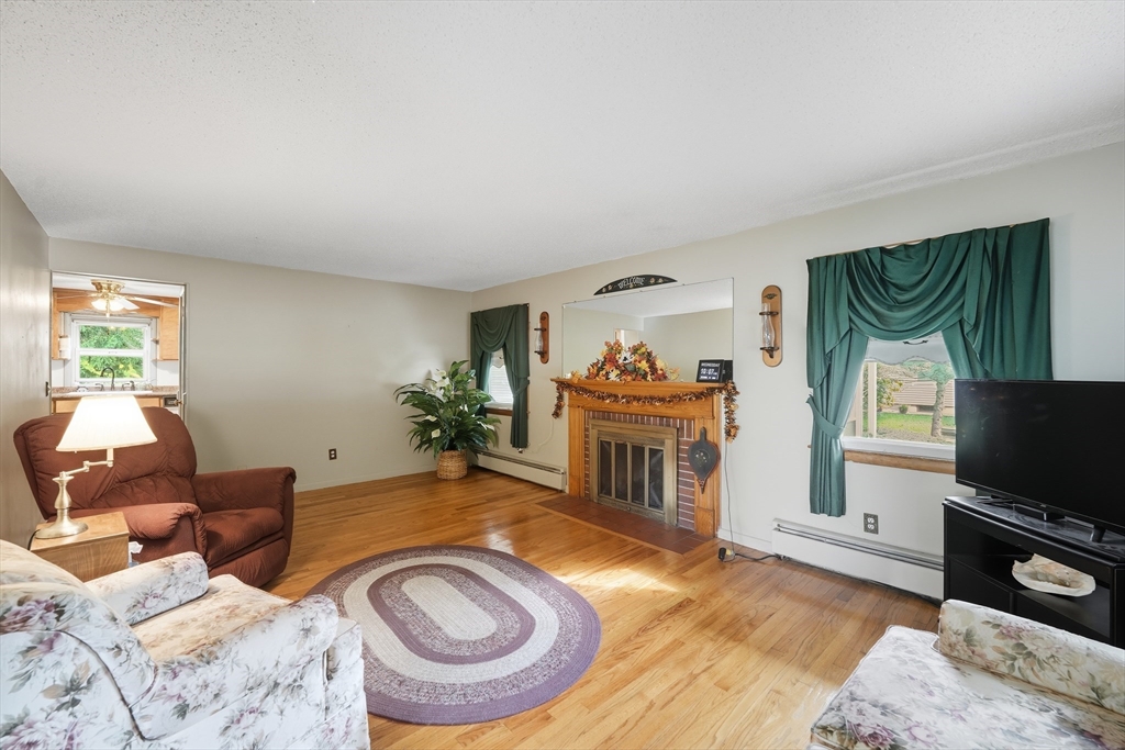 95 Meadowbrook Road Agawam, MA 01001 - Photo 17 of 39 a living room with furniture a flat screen tv and a fireplace