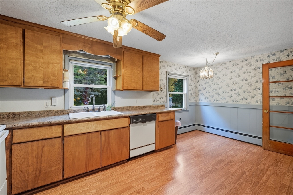 95 Meadowbrook Road Agawam, MA 01001 - Photo 20 of 39 a kitchen with granite countertop a stove a sink and a refrigerator with wooden floors