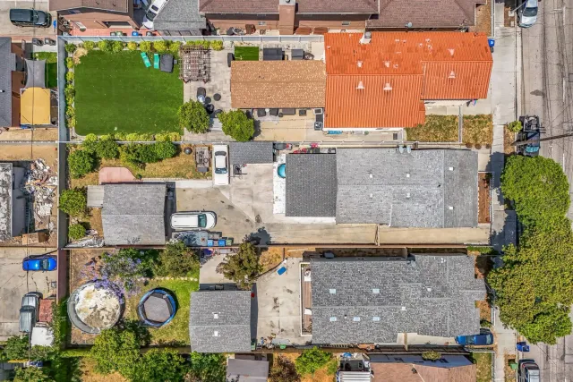 an aerial view of residential houses with outdoor space and parking