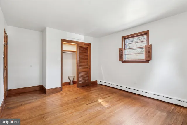 an empty room with wooden floor and closet