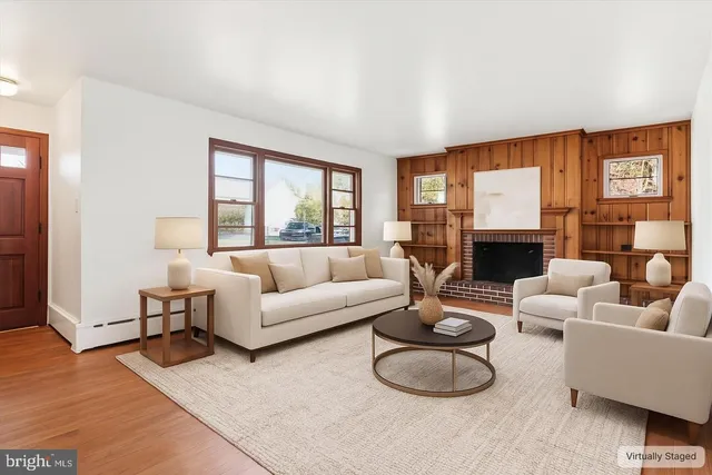 a living room with furniture a large window and a fireplace