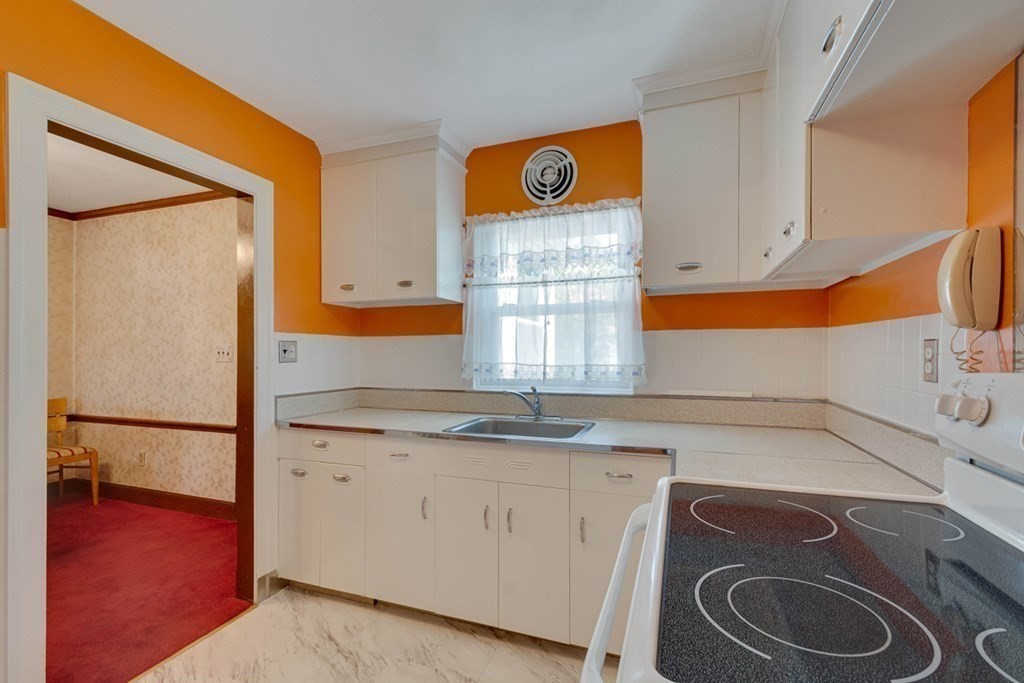 11 Stimson Street Boston, MA 02132 - Photo 12 of 32 a kitchen with a sink a stove and cabinets