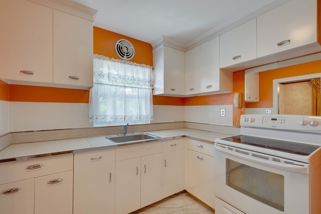 11 Stimson Street Boston, MA 02132 - Photo 13 of 32 a kitchen with granite countertop white cabinets and white appliances