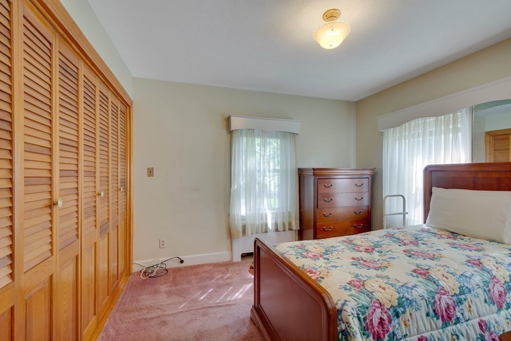 11 Stimson Street Boston, MA 02132 - Photo 18 of 32 a bedroom with a bed and a chandelier
