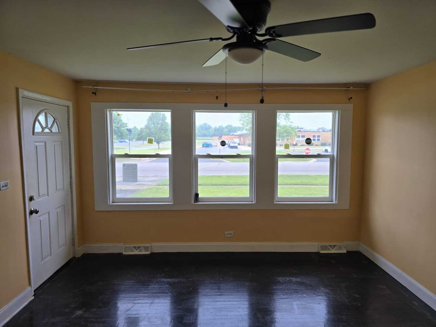 3014 West 163rd Street Markham, IL 60428 - Photo 2 of 18 an empty room with wooden floor fan and windows