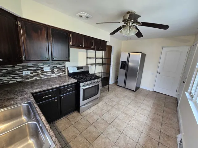 a kitchen with stainless steel appliances granite countertop a refrigerator and a sink