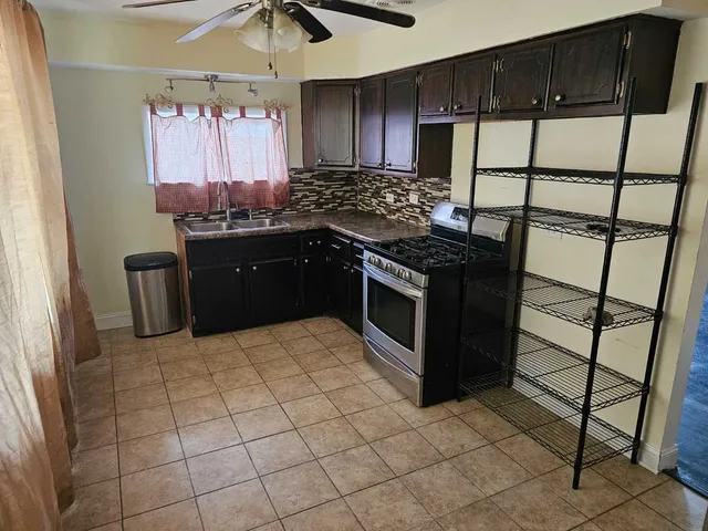 a kitchen with stainless steel appliances granite countertop a stove a sink and a refrigerator