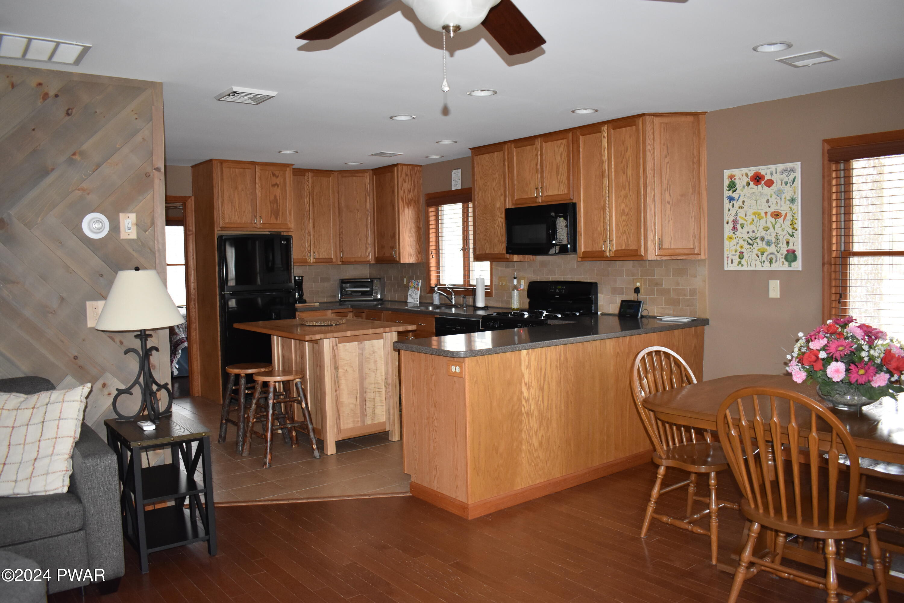 800 Rimrock Court Hawley, PA 18428 - Photo 11 of 30 a kitchen with stainless steel appliances granite countertop a stove top oven a sink a dining table and chairs with wooden floor