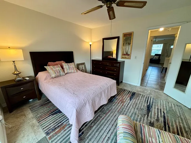 a bedroom with a bed and a mirror on dresser