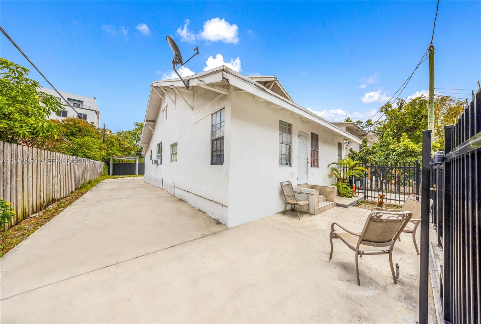 127 Southwest 7th Avenue Miami, FL 33130 - Photo 5 of 6 a view of a white house with a small yard and wooden fence
