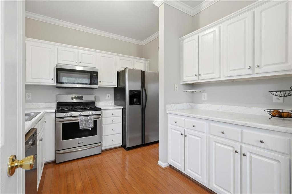 2664 Reston Court Northwest Kennesaw, GA 30144 - Photo 11 of 28 a kitchen with white cabinets and stainless steel appliances