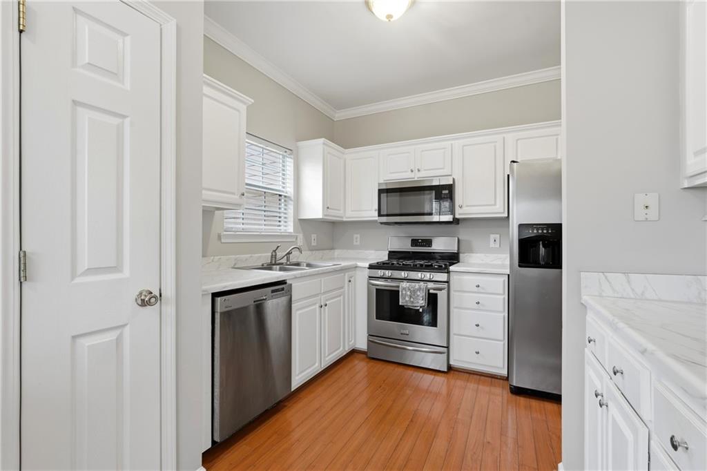 2664 Reston Court Northwest Kennesaw, GA 30144 - Photo 10 of 28 a kitchen with stainless steel appliances a sink cabinets and a wooden floor