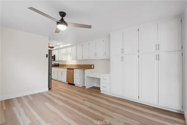 a open kitchen with white cabinets and stainless steel appliances