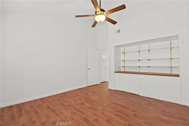 an empty room with closet and fan