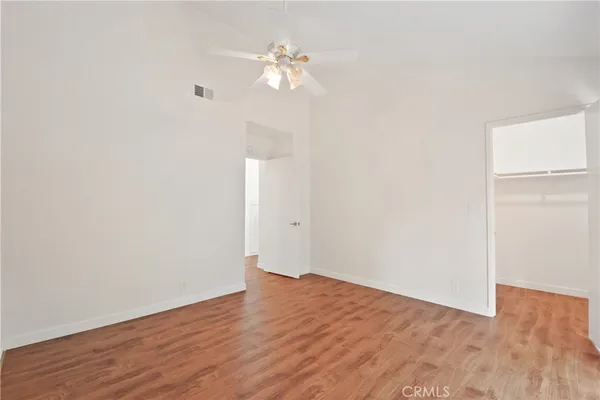 a view of a room with wooden floor and a ceiling fan