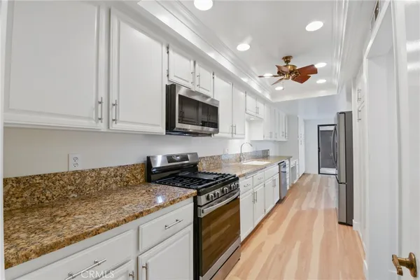 a large kitchen with stainless steel appliances granite countertop a stove a sink dishwasher and a microwave oven on the kitchen countertops