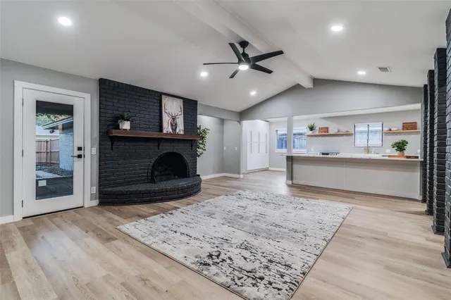 a living room with furniture a fireplace and a ceiling fan
