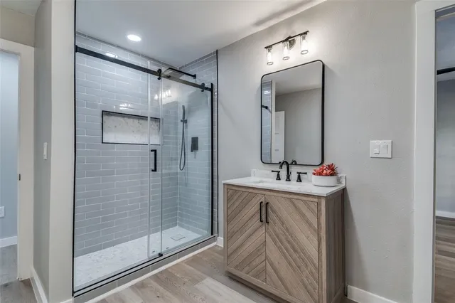 a bathroom with a sink a mirror and shower