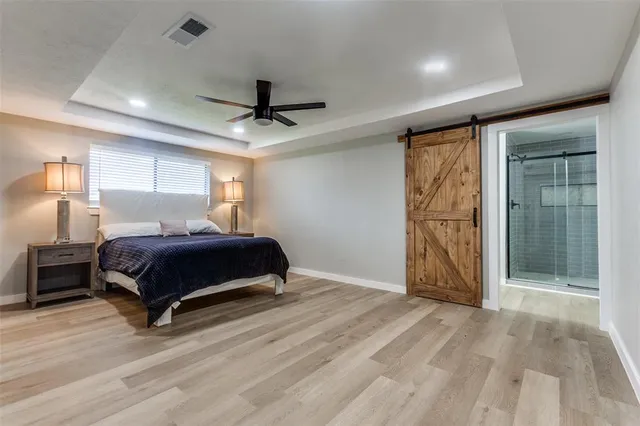 a spacious bedroom with a large bed and a ceiling fan