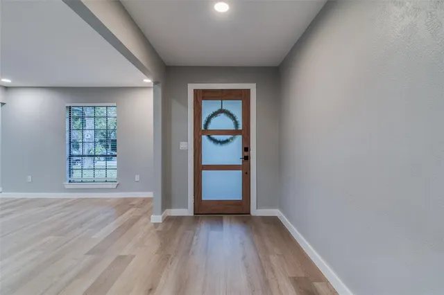 an empty room with wooden floor cabinet and windows