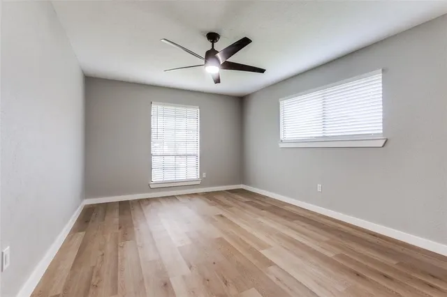 a bedroom with a large bed and a ceiling fan