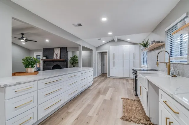 a large kitchen with kitchen island a large counter space a sink stainless steel appliances and cabinets