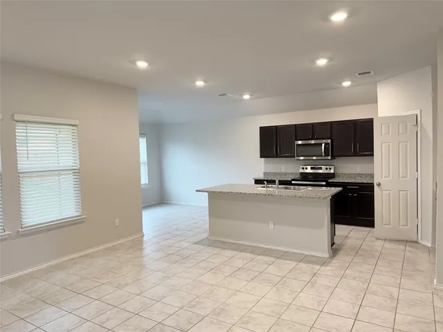 a kitchen with granite countertop white cabinets and stainless steel appliances