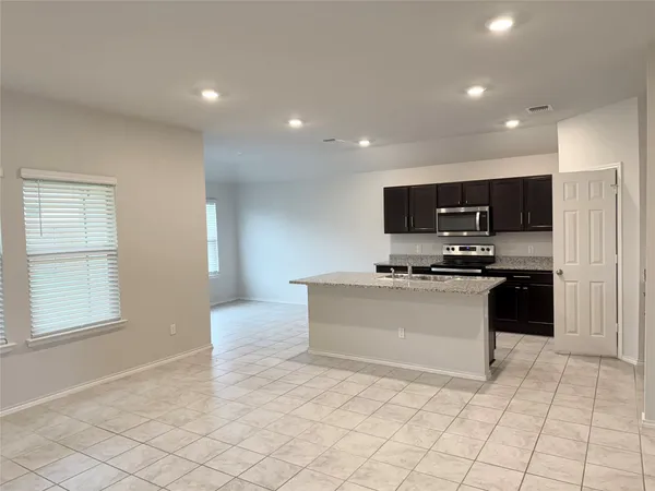 a kitchen with granite countertop white cabinets and stainless steel appliances