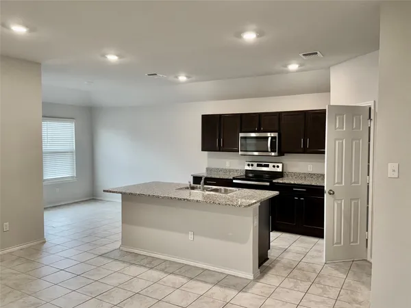 a kitchen with stainless steel appliances granite countertop a stove a sink and a refrigerator