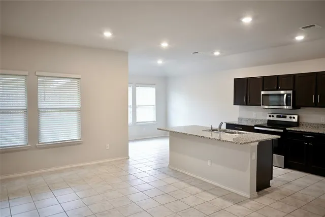 a kitchen with stainless steel appliances granite countertop a stove top oven a sink a counter top space and cabinets