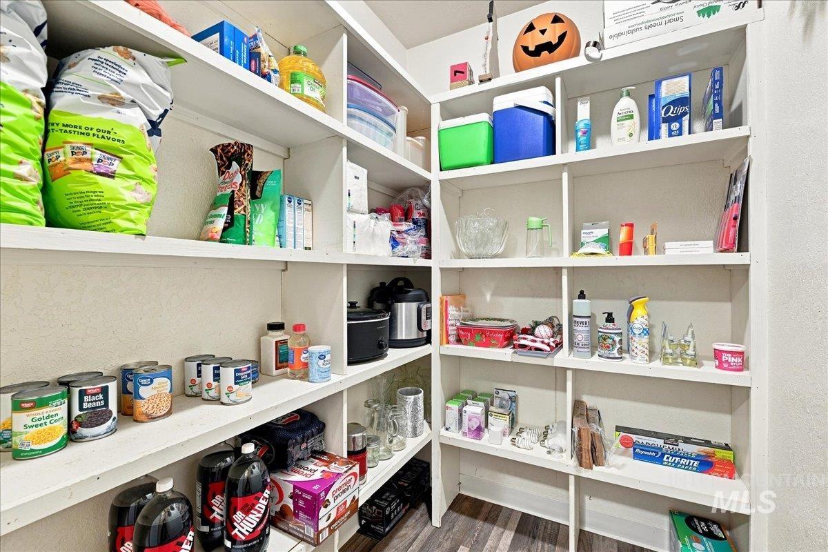 26201 Hop Road Caldwell, ID 83607 - Photo 28 of 45 Spacious pantry with floor-to-ceiling white shelving, ample storage capacity for dry goods and household essentials, built-in organization system, and convenient access to kitchen appliances including a black coffee maker