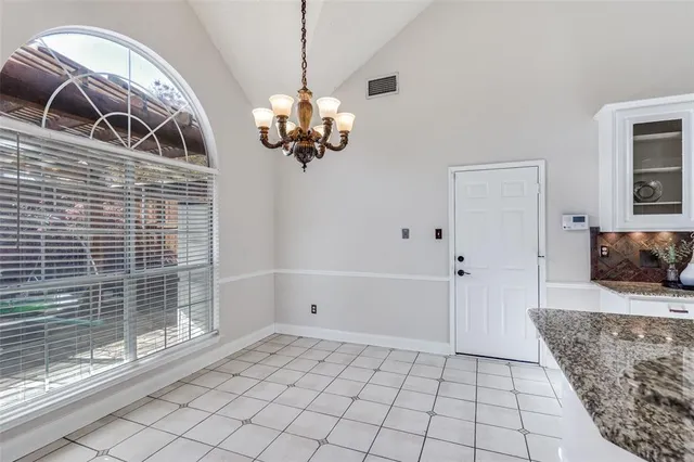 a large kitchen with white cabinets and stainless steel appliances