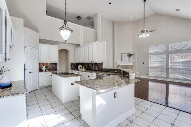 a kitchen with granite countertop a sink stove and cabinets
